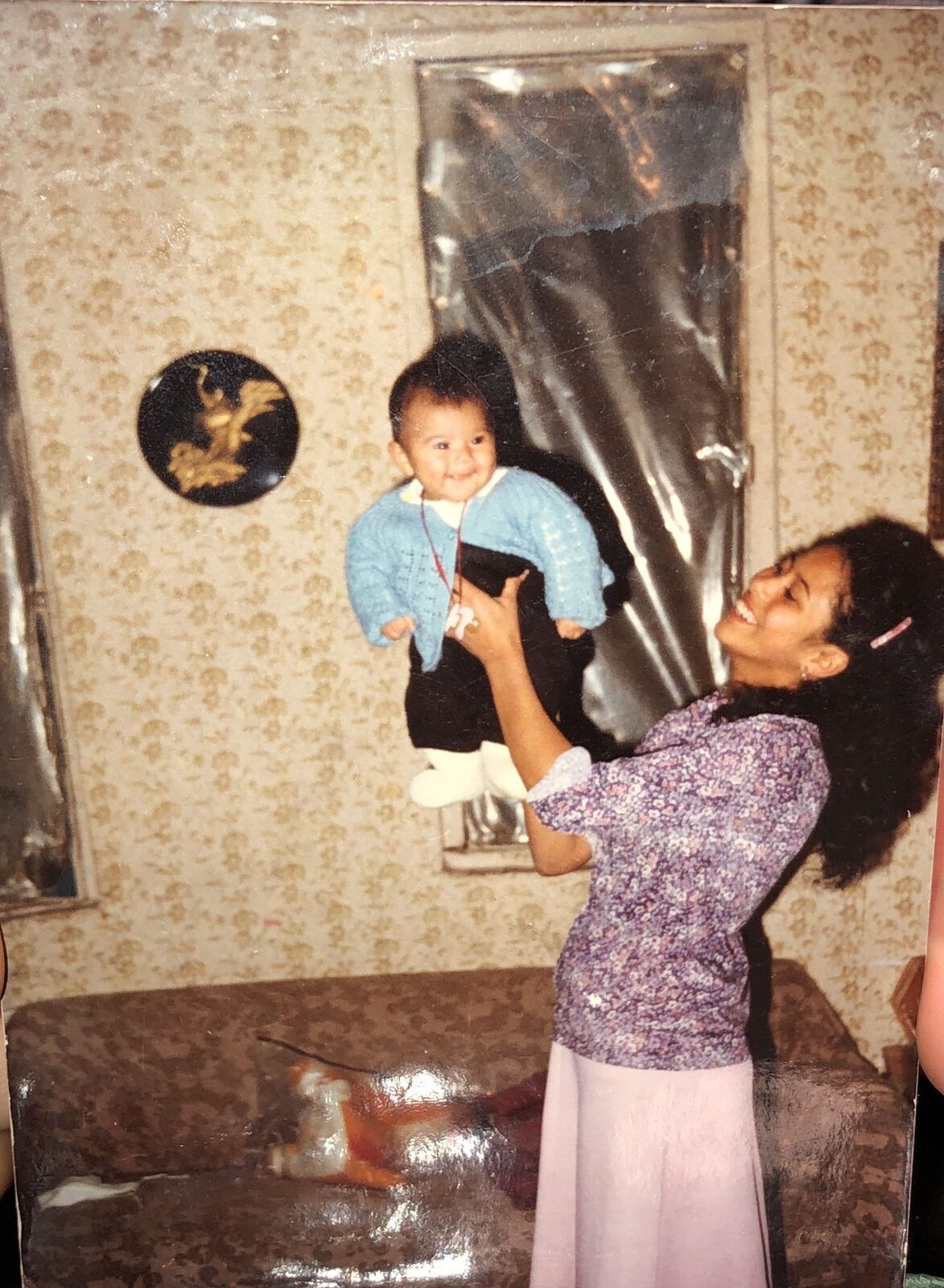 A family photo of baby Jennifer being lifted up joyfully