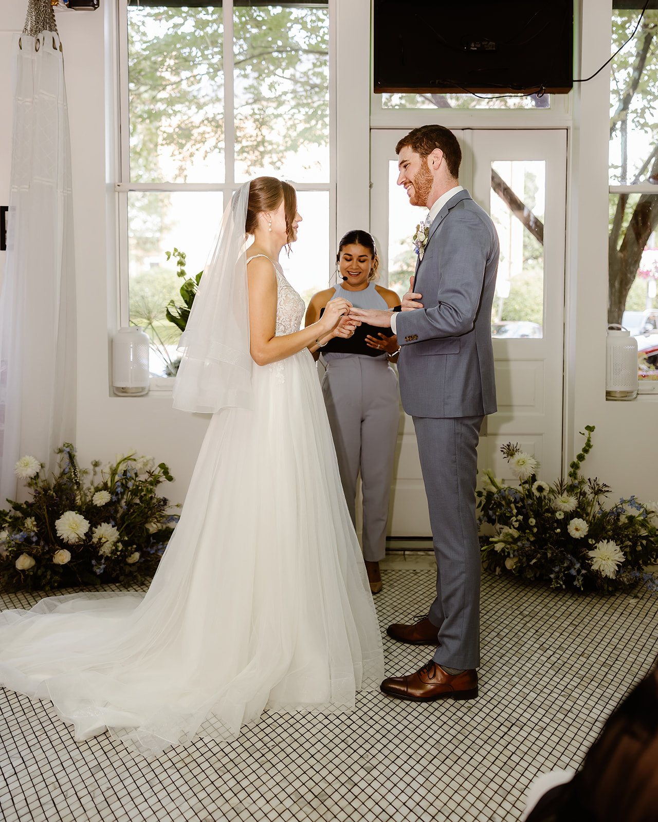 Jennifer officiating a wedding ceremony as the couple exchanges rings