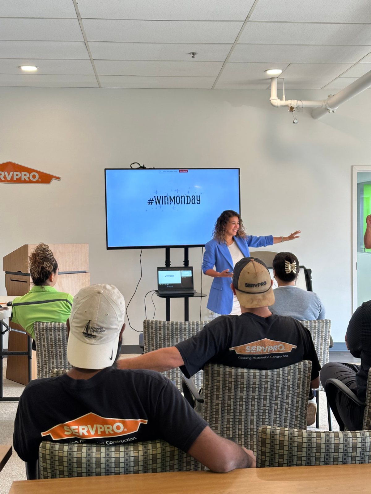 Jennifer leading a team meeting in front of a screen