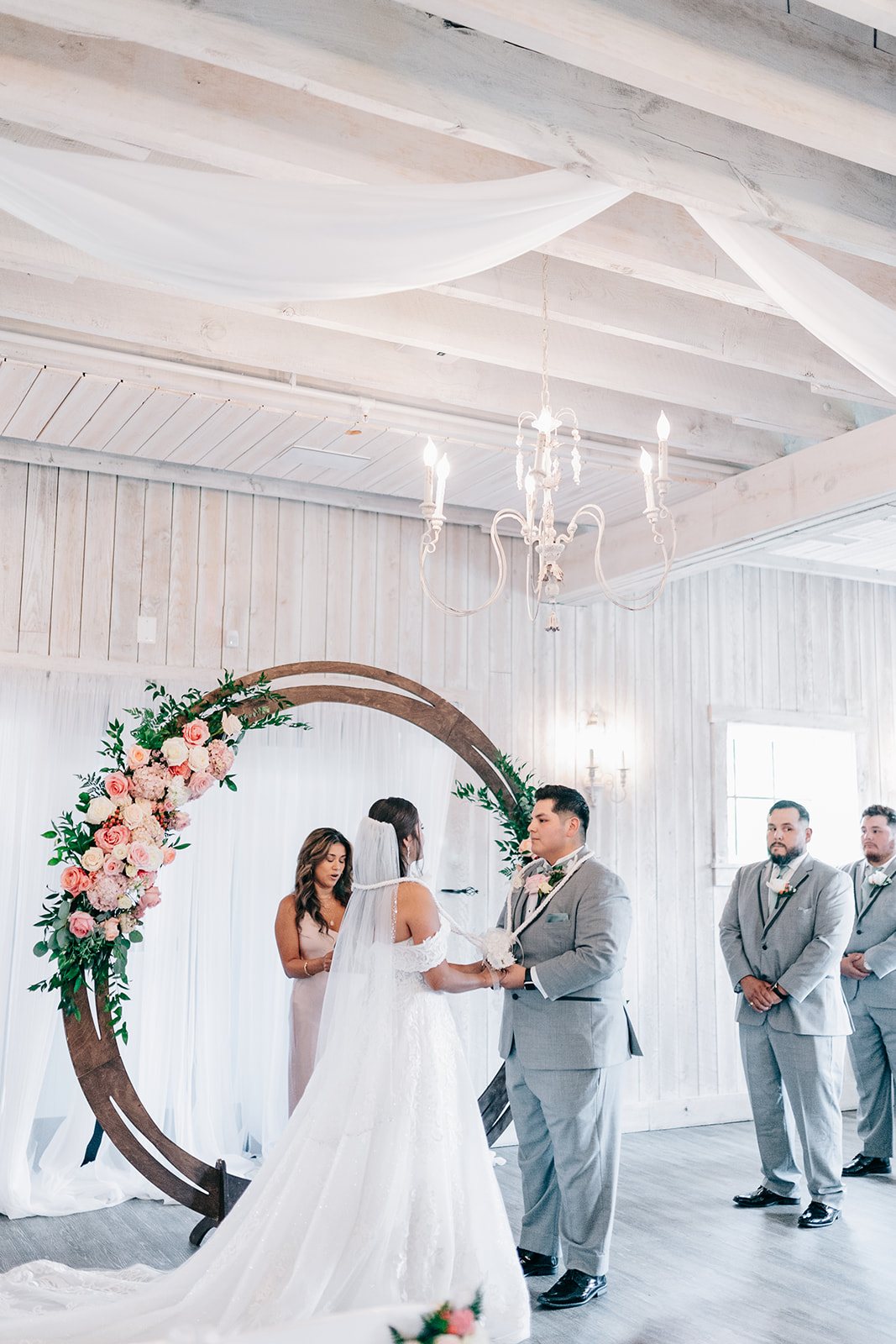 Jennifer officiating a ceremony under a floral arch